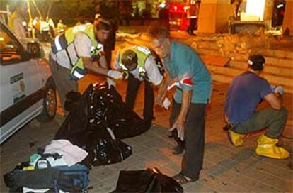 Los servicios de emergencia trasladan una bolsa con los restos de uno de los fallecidos en el atentado.