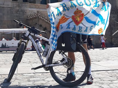 Miguel Cardiel con la bandera del Zaragoza frente a la catedral de Santiago de Compostela tras completar un tramo del Camino de Santiago.