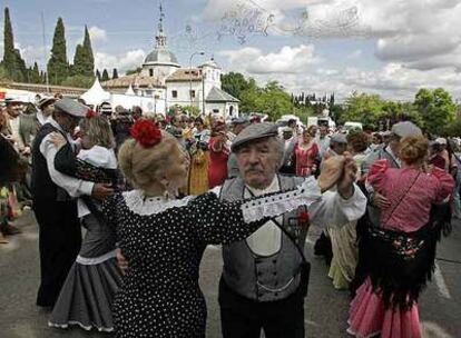 Madrileños vestidos de chulapos bailan junto a la ermita del Santo en la pradera de San Isidro.