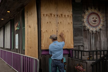 A man places plywood in front of a store ahead of the arrival of Hurricane Idalia in Cedar Key, Florida, U.S., on August 29, 2023.