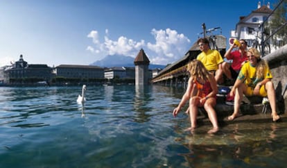 Varios jovenes junto al puente de madera de Kapellbrücke, en Lucerna, Suiza