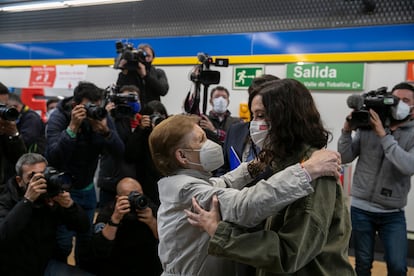 La presidenta de Madrid se abraza con una mujer en la estación de Metro de Villaverde Alto (Madrid).