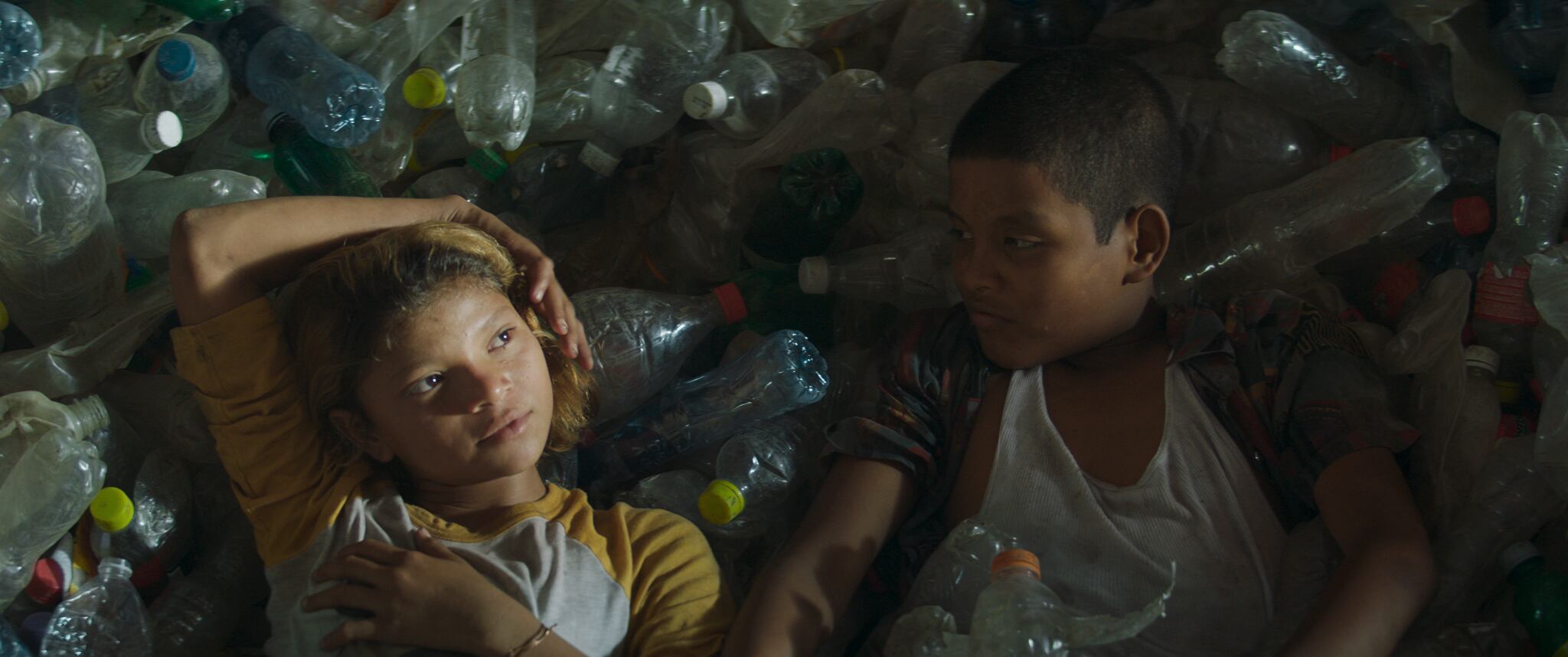 María recostada sobre basura, en un fotograma de la película 'La hija de todas las rabias' (2021).
