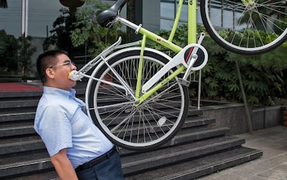 El empresario haciendo malabares con un modelo de bicicleta como la que donó a varios centenares de ciudadanos de Pekín en 2012.