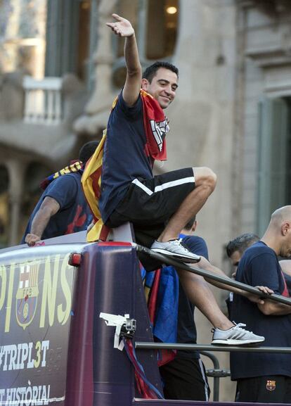 Piqué junto a las tres copas anima a los aficionados con 3 dedos de cada mano alzados.