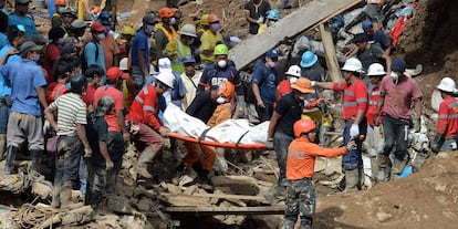 Los equpos de rescate portan el cuerpo de una víctima del desprendimiento de tierra en Itogon.
