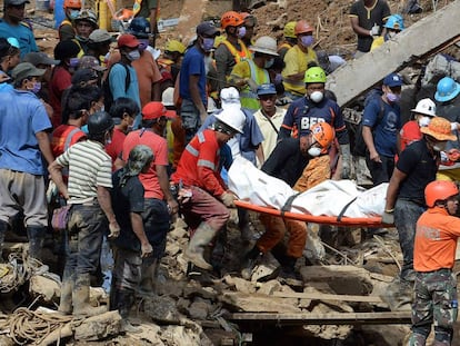 Los equpos de rescate portan el cuerpo de una víctima del desprendimiento de tierra en Itogon.