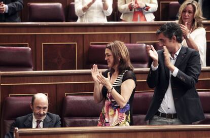 El líder del PSOE, Alfredo Pérez Rubalcaba (i), recibe el aplauso de sus compañeros socialistas, la portavoz parlamentaria Soraya Rodríguez (c), y el secretario general del grupo en el Congreso y aspirante a liderar el partido, Eduardo Madina (d), así como de los diputados de todos los grupos parlamentarios, que le han aplaudido durante casi un minuto, al finalizar el debate en el pleno de la Cámara baja. Rubalcaba ha anunciado que el próximo mes de septiembre abandonará su escaño en el Congreso y volverá a impartir clases en la facultad de Químicas