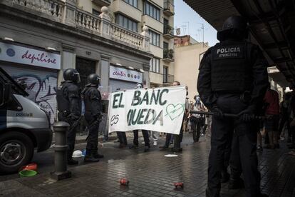 Manifestantes frente a los mossos, en el barrio de Gràcia.