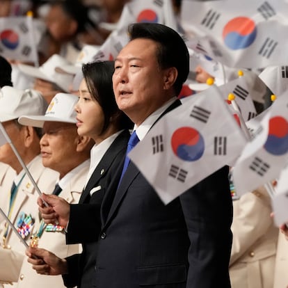 South Korean President Yoon Suk Yeol, center right, his wife Kim Keon Hee wave the national flags during a ceremony to mark the 74th anniversary of the outbreak of the Korean War in Daegu, South Korea, Tuesday, June 25, 2024. (AP Photo/Ahn Young-joon, Pool)