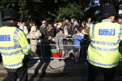 Dos policías británicos observan a la gente congregada para ver al Papa