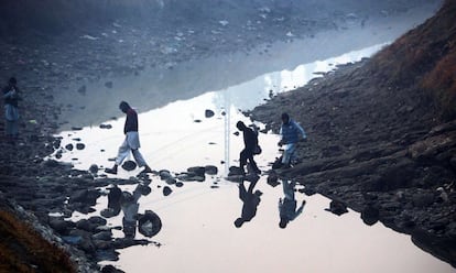 Jóvenes cruzan un arroyo a las afueras de Jalalabad (Afganistán).