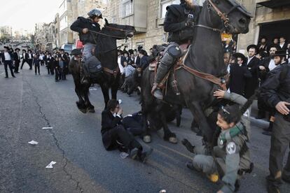 Varios miembros de la policía montada de Israel atropellan a una mujer policía mientras tratan de dispersar a judíos ultraortodoxos durante una protesta contra el reclutamiento del Ejército israelí, en el centro de Jerusalén (Israel).