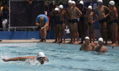 Michael Phelps nada ante la mirada de los alumnos.