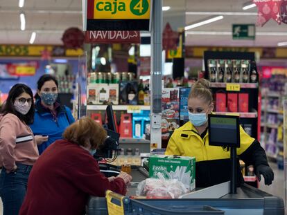 Una cajera atiende a una mujer en un supermercado de Alcorcón (Madrid) el 2 de enero.