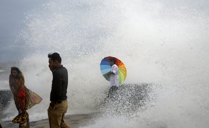 Un hombre sostiene un paraguas en la costa del Mar Arábigo mientras disfruta de las olas de marea alta durante el monzón de este año en Mumbai, India.