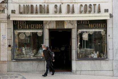 Un hombre con mascarilla sale de una librería en Lisboa.