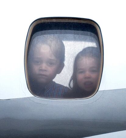 Los príncipes Jorge y Carlota miran por la ventanilla del avión al aterrizar en Varsovia.