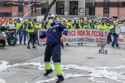 Trabajadores de la factoría pontevedresa de ENCE se concentran con chalecos amarillos, humo, pancartas y tirando rollos de papel higiénico en las inmediaciones del Ministerio de Transición Ecológica en Madrid
