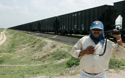 Un guardia detiene el tránsito mientras pasa un tren, en Uribia, en 2005.