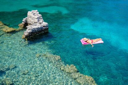 Una mujer nada en flotar sobre ruinas de la ciudad sumergida en la isla de Kekova (Turquía)