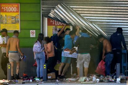 La gente saquea un supermercado en Puente Alto, área metropolitana de Santiago, el 20 de octubre de 2019.