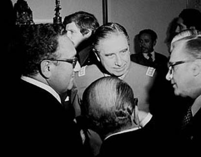 Henry Kissinger (izquierda) junto al general Augusto Pinochet charlan con dos hombres no identificados.