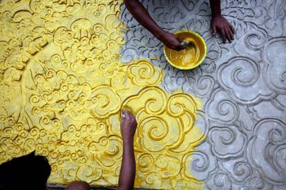 Varios artistas indios trabajan sobre un lienzo improvisado de madera, metal, bambú y papel de colores, bajo el tema 'Salvad el medioambiente' del pintor y escultor Pradip Das durante los preparativos del festival Durgá Puyá en Calcuta, India.