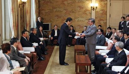 El portavoz del Parlamento japonés, Takahiro Yokomichi (a la derecha), recoge el informe sobre el accidente en la central nuclear de Fukushima.