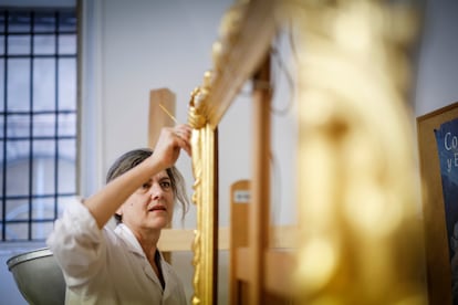 Una restauradora trabaja en el dorado de un marco en el Taller de dorados y estucos de Patrimonio Nacional, en el Palacio Real de Madrid, el 29 de mayo.