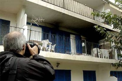 Un hombre fotografía el balcón desde el que se lanzaron en llamas la mujer fallecida y, posteriormente, su marido.