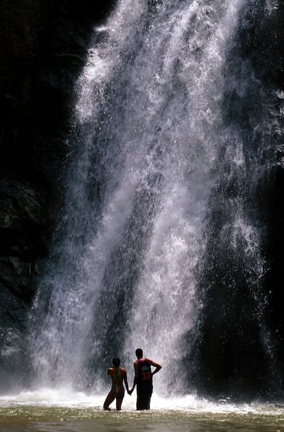 Dos personas frente al salto de Baiguate, en Jarabacoa.