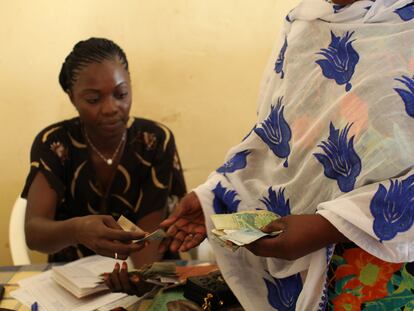 Una mujer devuelve un préstamo a otra en Senegal.