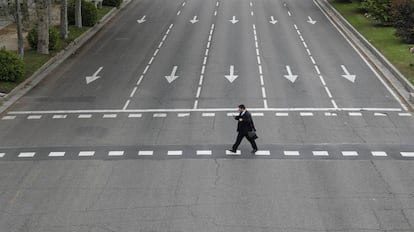 Un hombre cruza un calle vacía en Madrid. 