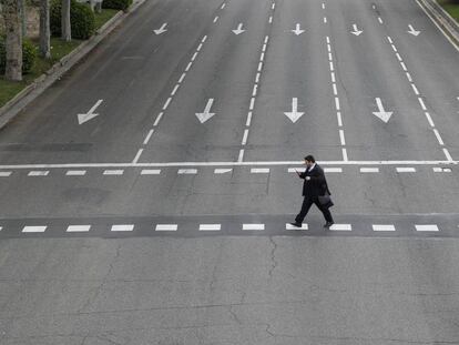 Un hombre cruza un calle vacía en Madrid. 