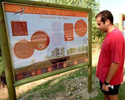 Un excursionista, ante un panel explicativo con las rutas propuestas para la observación de aves en El Pardo.