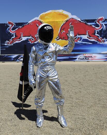 Jorge Lorenzo planta su bandera usando un traje espacial tras ganar la carrera de MotoGP en el Gran Premio Red Bull en Laguna Seca.
