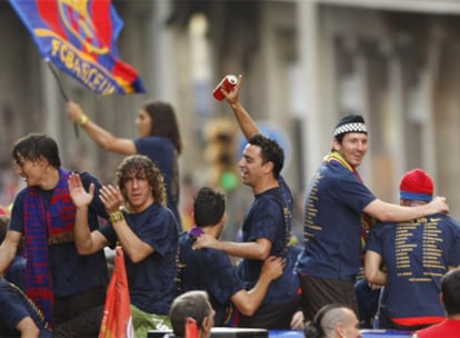 Bojan, Puyol, Xavi y Messi (de izquierda a derecha) responden a los vítoresde los aficionados durante el desfile triunfal del equipo azulgrana
por las calles
de Barcelona.