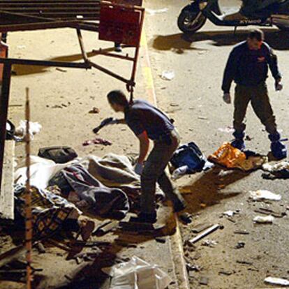 Miembros de los equipos de rescate inspeccionan los cadáveres de víctimas de la explosión en Tel Aviv.