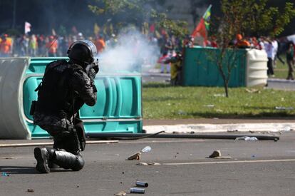 Un antidisturbio frente a los protestantes de la manifestación.