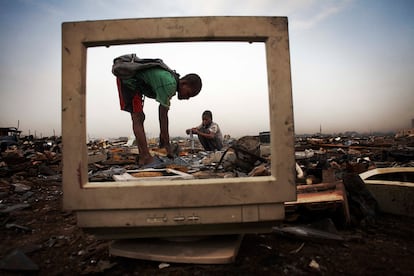 De la serie fotográfica 'Vertedero de basura 2.0', de Andrew McConnell, Unos niños recogen la parte metálica de una pantalla, en Agbogbloshie, barrio de Accra, Gana. No se protegen para manipular productos químicos como el mercurio o el plomo (Fotografía cedida por los Premios Luis Valtueña)