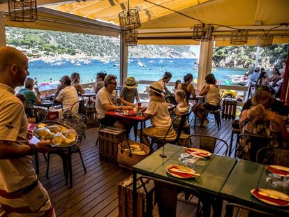 Un cambrer porta una safata amb peix fresc al xiringuito-restaurant Toc al Mar, a la cala d'Aiguablava, a Begur.