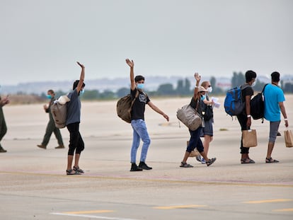 Un grupo de jóvenes afganos saludan, antes de subir a un avión estadounidense para ser trasladados a Alemania, en la base aérea de Torrejón de Ardoz, el 24 de agosto de 2021, en Madrid.