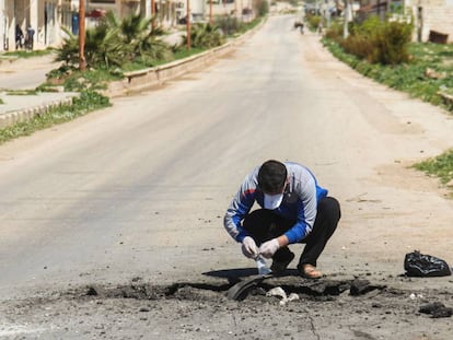 Un sirio recoge muestras de supuestos componentes químicos tras el ataque del martes.