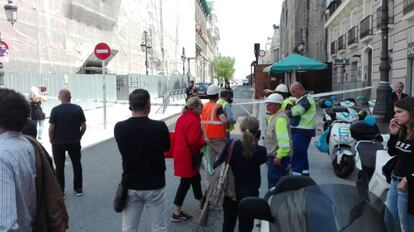 Viandantes y trabajadores ante la zona acordonada.