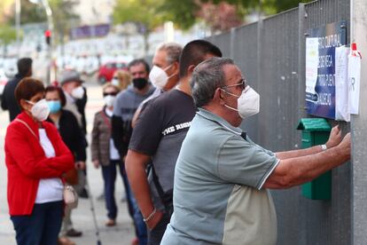 People wait in line outside a cultural centre to take a coronavirus antigen test in the Madrid neighborhood of Vallecas.