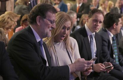Rajoy muestra su móvil a Cifuentes, durante un acto del PP.