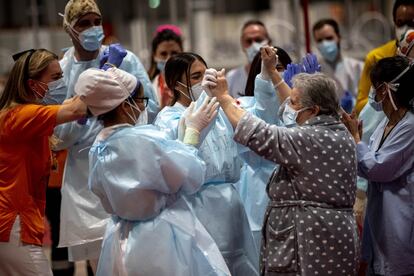 Una paciente ingresada por coronavirus en el hospital de Ifema baila con un grupo de sanitarios tras el aplauso diario de las ocho de la tarde de este jueves. El dato de pacientes dados de alta en España desde el comienzo de la crisis asciende a 112.050.