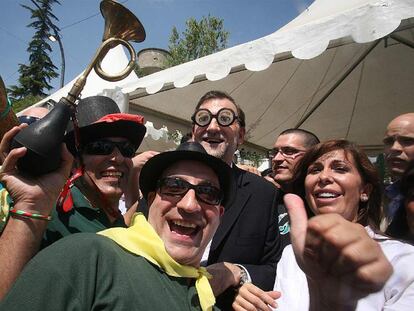 Rajoy, con gafas de broma, y Alicia Sánchez-Camacho, ayer en Lleida con los miembros de una charanga.