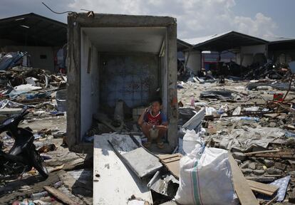 Un joven realiza una llamada desde el interior de la estructura de un baño que resistió al terremoto en Palu (Indonesia). 